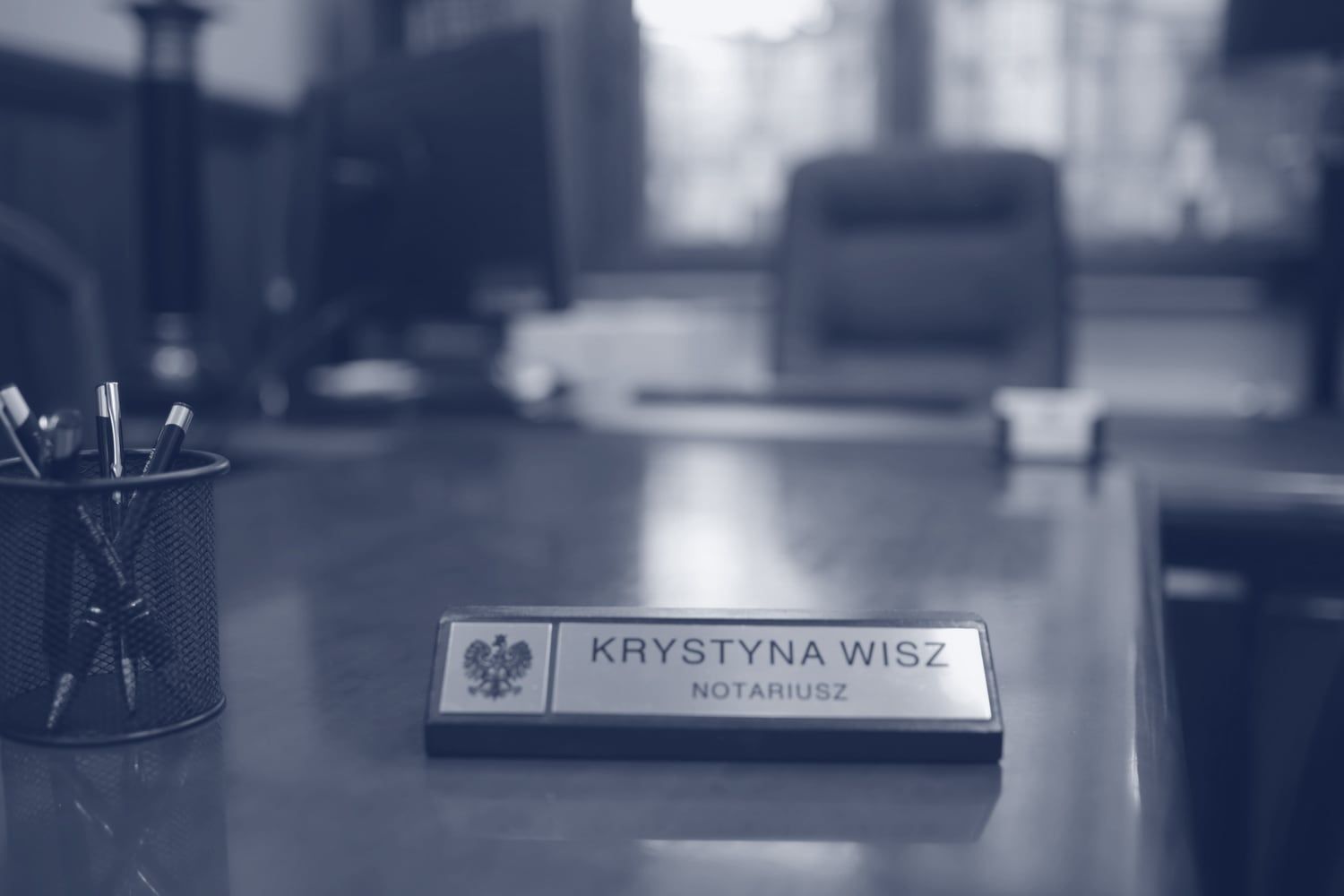 Tabliczka z napisem Krystyna Wisz, notariusz, na biurku